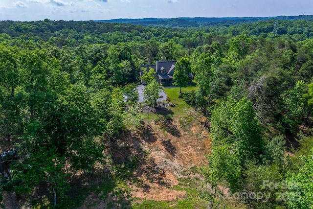 aerial view of property's location with a heavily wooded area