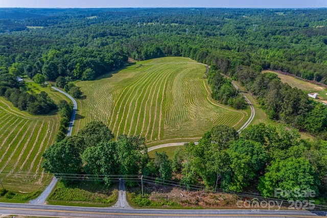 aerial view of property and surrounding area with a heavily wooded area