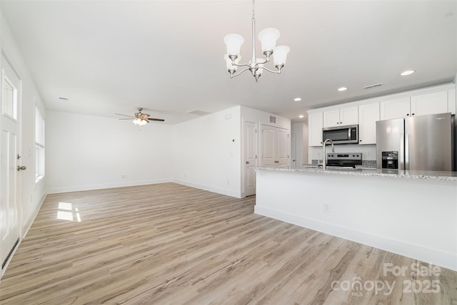 kitchen featuring appliances with stainless steel finishes, light wood-type flooring, white cabinetry, baseboards, and recessed lighting
