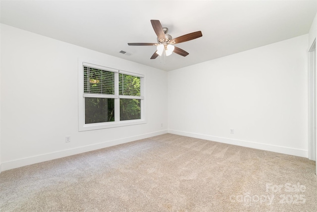 empty room with baseboards, light colored carpet, and a ceiling fan