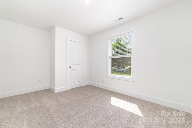 carpeted empty room featuring baseboards