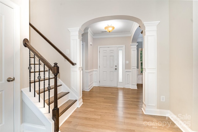 140 Wintergreen Ct, Lexington, NC 27295 - foyer entrance featuring arched walkways, light wood-type flooring, ornamental molding, a wainscoted wall, and a decorative wall