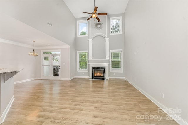 140 Wintergreen Ct, Lexington, NC 27295 - unfurnished living room featuring a ceiling fan, a chandelier, a fireplace with flush hearth, light wood-style flooring, and baseboards
