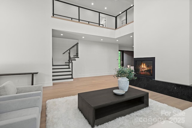 78 Running Creek Trl Unit 93, Arden, NC 28704 - living room with wood finished floors, a towering ceiling, stairs, a premium fireplace, and recessed lighting