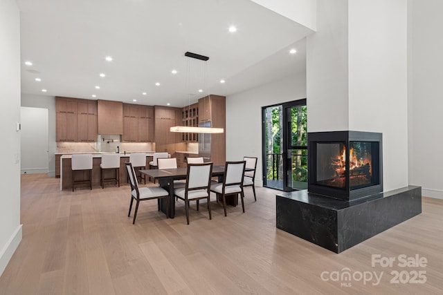 78 Running Creek Trl Unit 93, Arden, NC 28704 - dining space with light wood-style flooring, recessed lighting, a multi sided fireplace, and baseboards