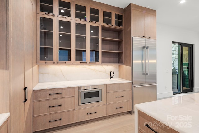 78 Running Creek Trl Unit 93, Arden, NC 28704 - kitchen with stainless steel built in refrigerator, decorative backsplash, light brown cabinets, light stone counters, and glass insert cabinets