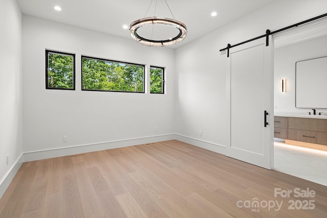 78 Running Creek Trl Unit 93, Arden, NC 28704 - unfurnished bedroom with a barn door, light wood-style floors, recessed lighting, a sink, and baseboards
