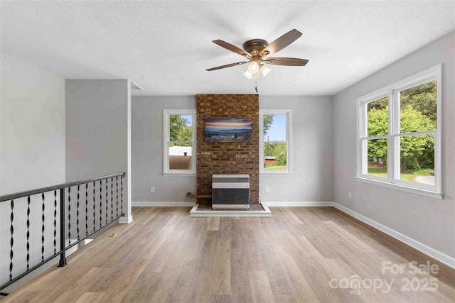 428 Jackson Rd, Fletcher, NC 28732 - unfurnished living room with wood finished floors, ceiling fan, baseboards, a brick fireplace, and heating unit