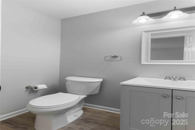 428 Jackson Rd, Fletcher, NC 28732 - half bathroom featuring toilet, vanity, wood finished floors, a textured ceiling, and baseboards