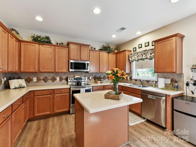 1564 Trippett St NW, Concord, NC 28027 - kitchen with stainless steel appliances, a sink, light wood finished floors, light countertops, and recessed lighting