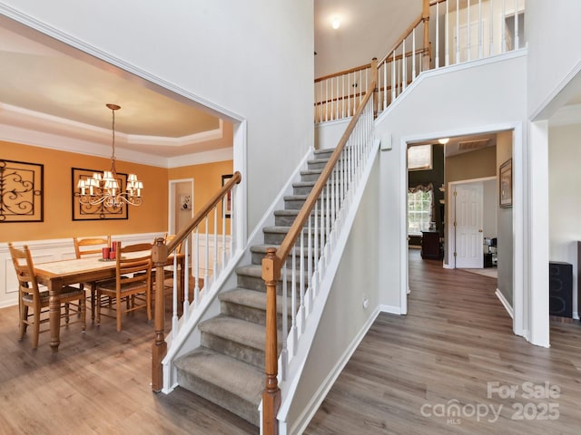 1564 Trippett St NW, Concord, NC 28027 - stairway featuring wood finished floors, a chandelier, crown molding, and a tray ceiling