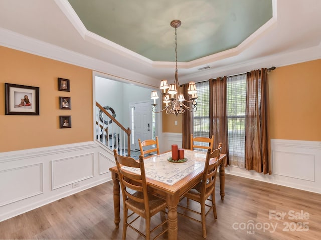 1564 Trippett St NW, Concord, NC 28027 - dining room with a tray ceiling, a wainscoted wall, a decorative wall, a chandelier, and stairs