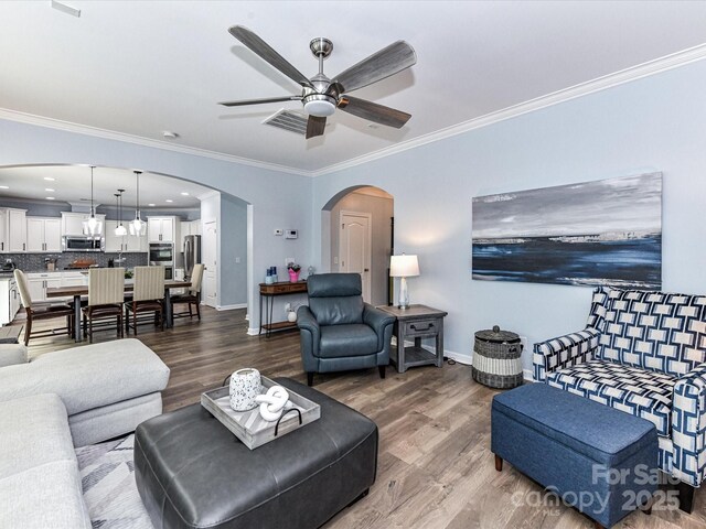 10800 Alabaster Dr, Davidson, NC 28036 - living area with arched walkways, wood finished floors, crown molding, a ceiling fan, and baseboards