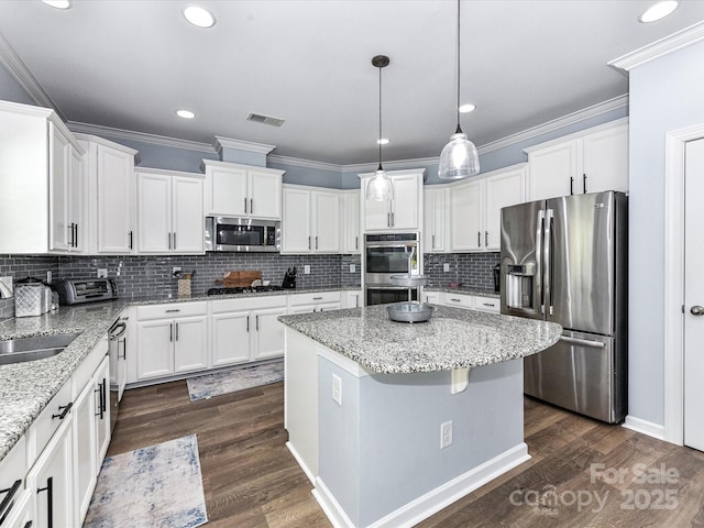 10800 Alabaster Dr, Davidson, NC 28036 - kitchen featuring stainless steel appliances, white cabinets, a center island, a sink, and ornamental molding