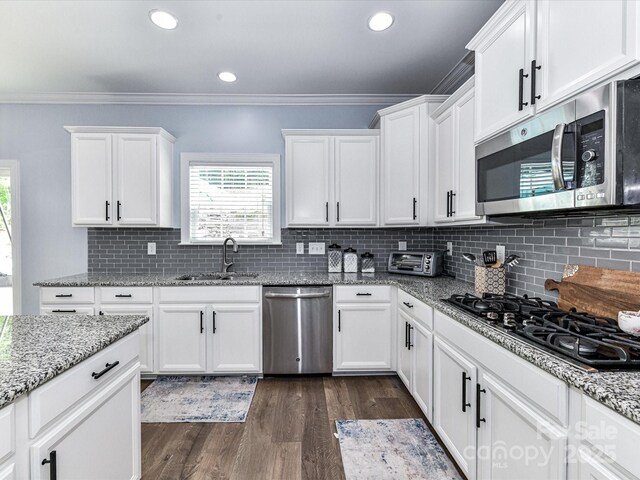 10800 Alabaster Dr, Davidson, NC 28036 - kitchen featuring appliances with stainless steel finishes, a sink, ornamental molding, dark wood-style flooring, and white cabinets