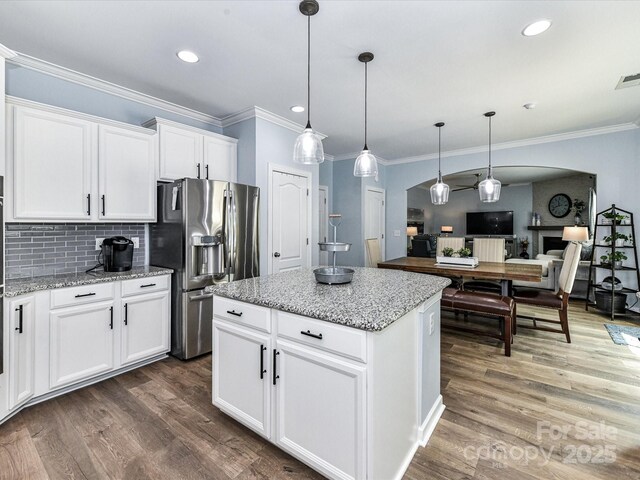 10800 Alabaster Dr, Davidson, NC 28036 - kitchen featuring stainless steel fridge with ice dispenser, crown molding, arched walkways, wood finished floors, and decorative backsplash