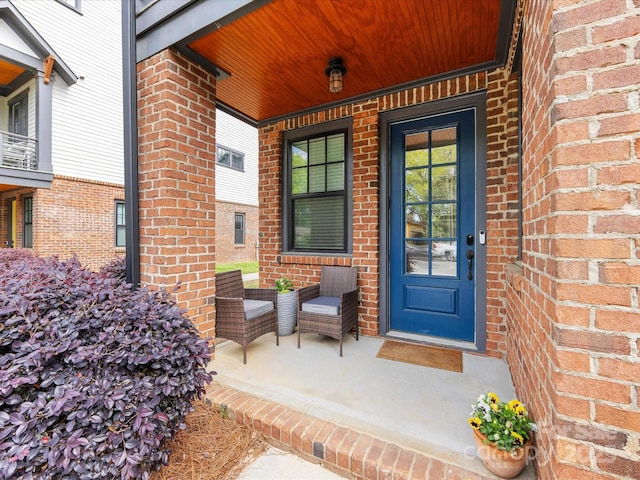entrance to property with covered porch and brick siding