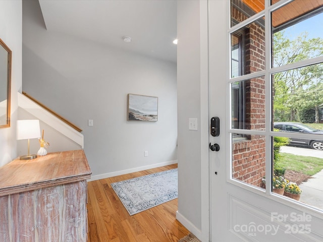 foyer with wood finished floors, stairs, and baseboards