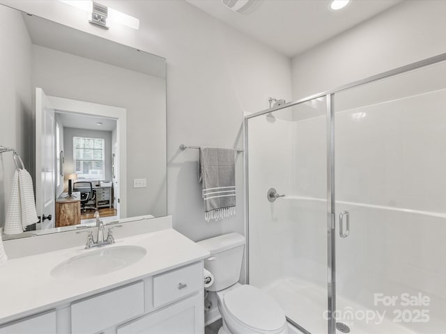 bathroom featuring toilet, a shower stall, vanity, recessed lighting, and ensuite bath