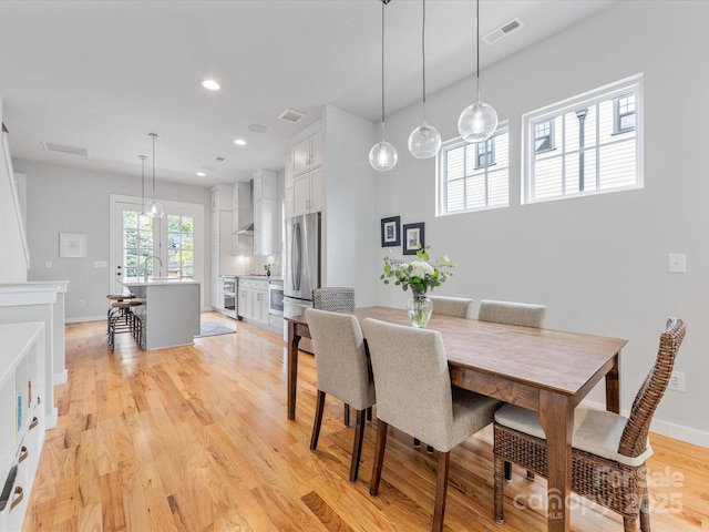dining space with light wood-type flooring, baseboards, and recessed lighting