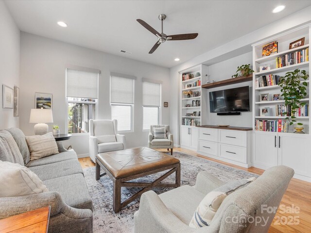 living room with a ceiling fan, light wood finished floors, and recessed lighting