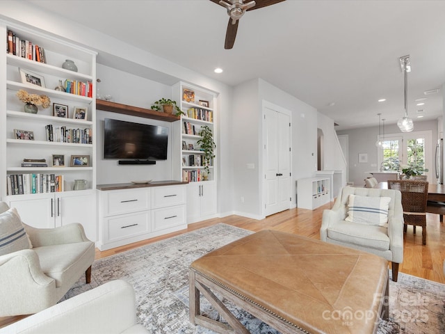 living room with ceiling fan, light wood-type flooring, recessed lighting, built in features, and baseboards