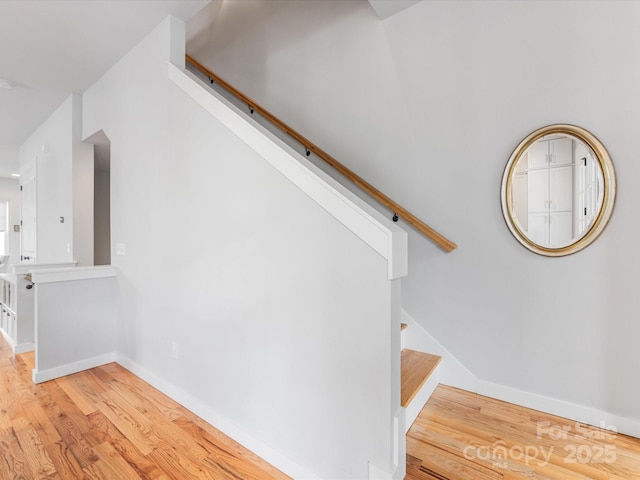 staircase with wood finished floors and baseboards