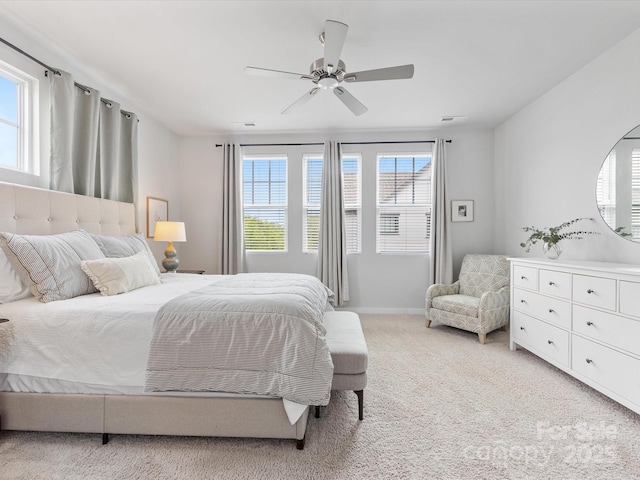 bedroom featuring light colored carpet, ceiling fan, and baseboards
