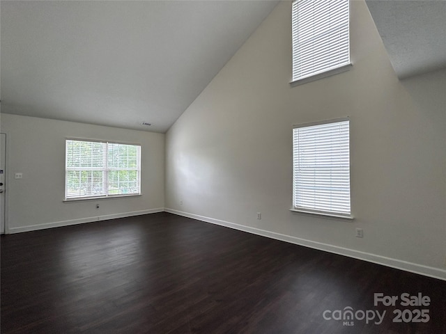 710 Woodington Ln, Charlotte, NC 28214 - empty room featuring dark wood-type flooring, baseboards, and high vaulted ceiling