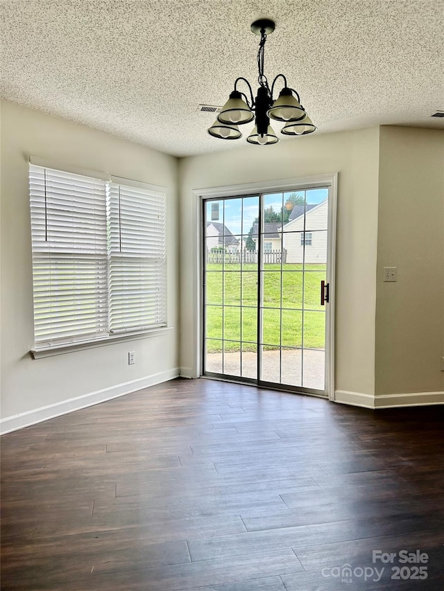 710 Woodington Ln, Charlotte, NC 28214 - unfurnished dining area with a chandelier, a textured ceiling, baseboards, and dark wood-style floors