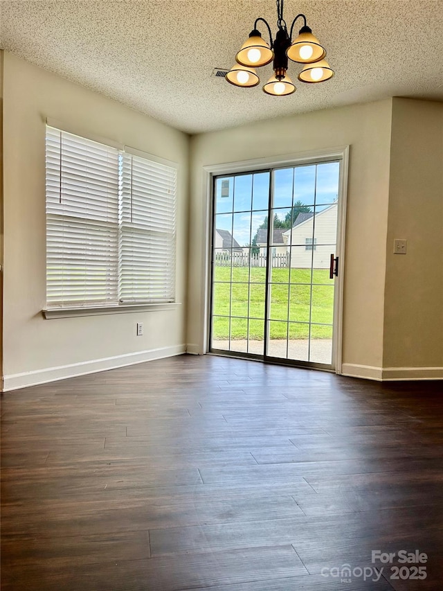 710 Woodington Ln, Charlotte, NC 28214 - unfurnished dining area featuring a chandelier, a textured ceiling, dark wood-style flooring, and baseboards