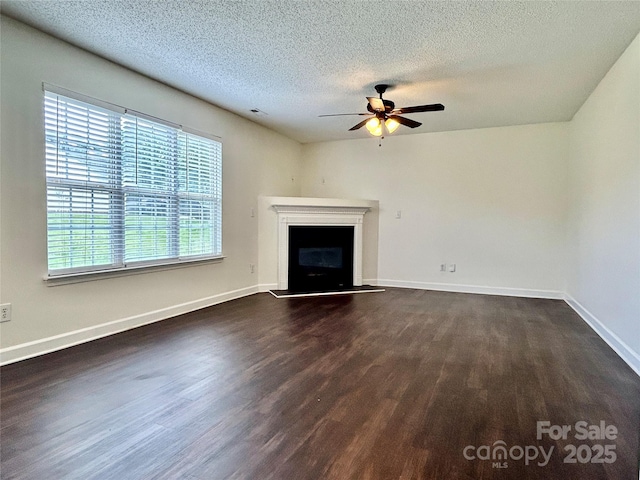710 Woodington Ln, Charlotte, NC 28214 - unfurnished living room with ceiling fan, dark wood-style floors, a fireplace with raised hearth, a textured ceiling, and baseboards