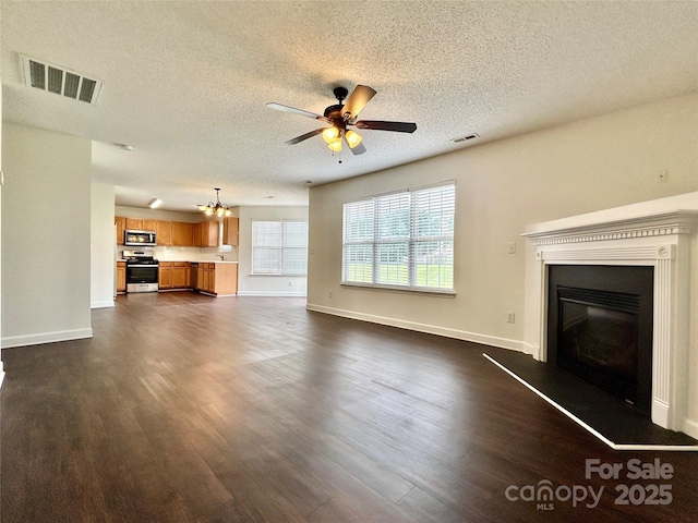 710 Woodington Ln, Charlotte, NC 28214 - unfurnished living room featuring dark wood-type flooring, a textured ceiling, ceiling fan, baseboards, and a chandelier
