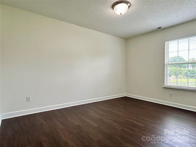 710 Woodington Ln, Charlotte, NC 28214 - unfurnished room with dark wood-type flooring, baseboards, and a textured ceiling