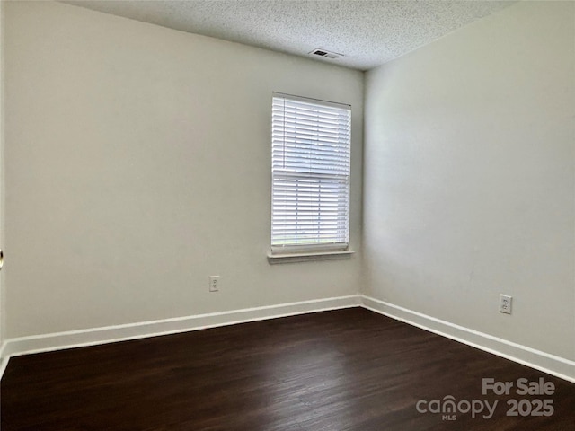 710 Woodington Ln, Charlotte, NC 28214 - spare room with dark wood-style floors, baseboards, and a textured ceiling