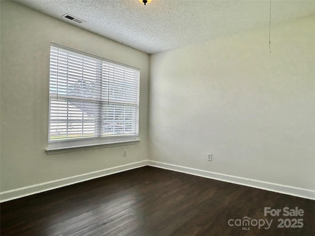 710 Woodington Ln, Charlotte, NC 28214 - unfurnished room featuring dark wood-style flooring, plenty of natural light, baseboards, and a textured ceiling