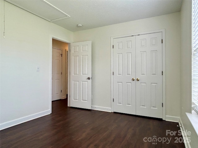 710 Woodington Ln, Charlotte, NC 28214 - unfurnished bedroom with dark wood-type flooring, baseboards, a closet, and a textured ceiling