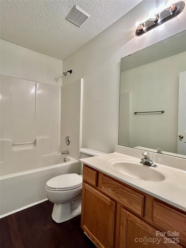 710 Woodington Ln, Charlotte, NC 28214 - full bath featuring a textured ceiling, wood finished floors, toilet, vanity, and shower / bath combination
