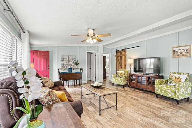 4920 Longfield St, Claremont, NC 28610 - living room with a barn door, wood finished floors, a textured ceiling, and ceiling fan