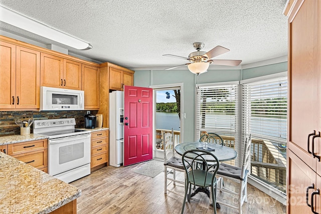 4920 Longfield St, Claremont, NC 28610 - kitchen with white appliances, light wood-style floors, ceiling fan, decorative backsplash, and a textured ceiling