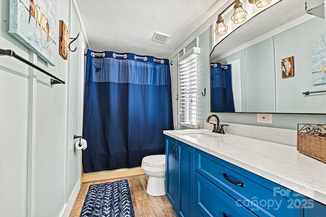 4920 Longfield St, Claremont, NC 28610 - bathroom featuring wood finished floors, toilet, vanity, a textured ceiling, and shower / bathtub combination with curtain