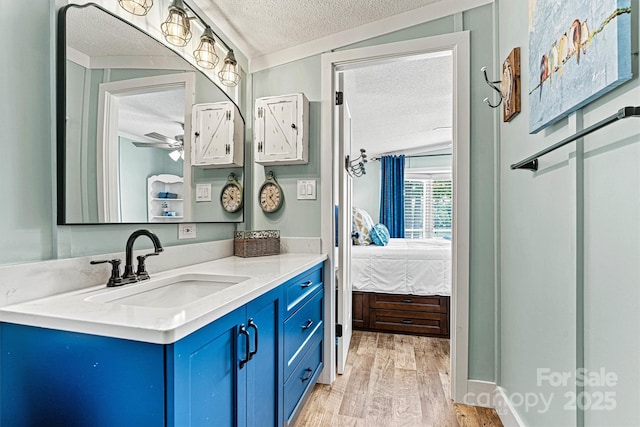 4920 Longfield St, Claremont, NC 28610 - ensuite bathroom with a textured ceiling, wood finished floors, vanity, and ceiling fan