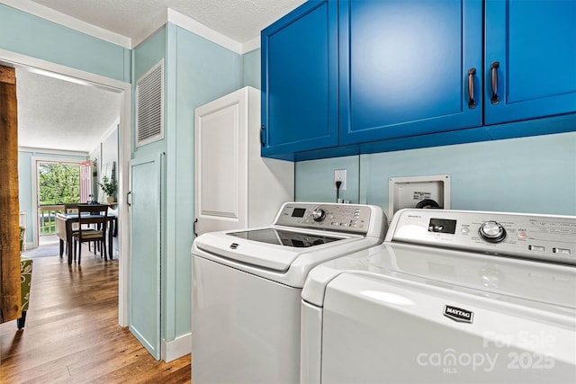 4920 Longfield St, Claremont, NC 28610 - laundry area featuring separate washer and dryer, cabinet space, wood finished floors, and a textured ceiling
