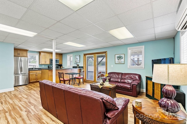 4920 Longfield St, Claremont, NC 28610 - living area featuring a wall mounted air conditioner, light wood-style flooring, a paneled ceiling, and baseboards