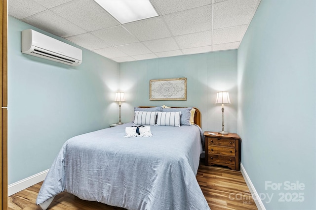 4920 Longfield St, Claremont, NC 28610 - bedroom with a wall mounted AC, wood finished floors, baseboards, and a drop ceiling