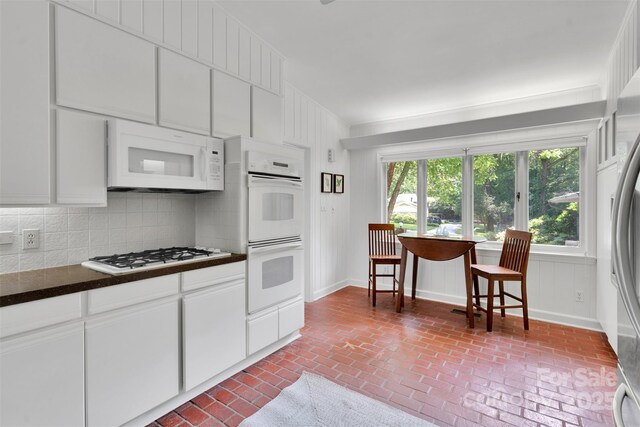 331 Glen Oaks Rd, Charlotte, NC 28270 - kitchen featuring white appliances, brick floors, dark countertops, and white cabinetry