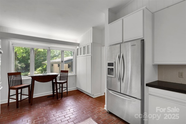 331 Glen Oaks Rd, Charlotte, NC 28270 - kitchen featuring stainless steel fridge with ice dispenser, brick patterned flooring, dark countertops, decorative backsplash, and white cabinetry