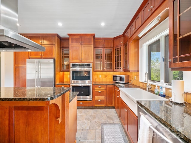 301 Fairway Ln, Spruce Pine, NC 28777 - kitchen with appliances with stainless steel finishes, island exhaust hood, backsplash, light stone finish floors, and a sink