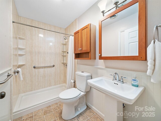 301 Fairway Ln, Spruce Pine, NC 28777 - bathroom featuring a shower stall, toilet, and wainscoting