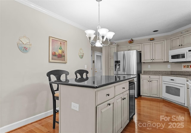 4101 Fairway Downs Ct Unit 9, Charlotte, NC 28277 - kitchen with white appliances, a kitchen bar, a chandelier, ornamental molding, and light wood-style flooring